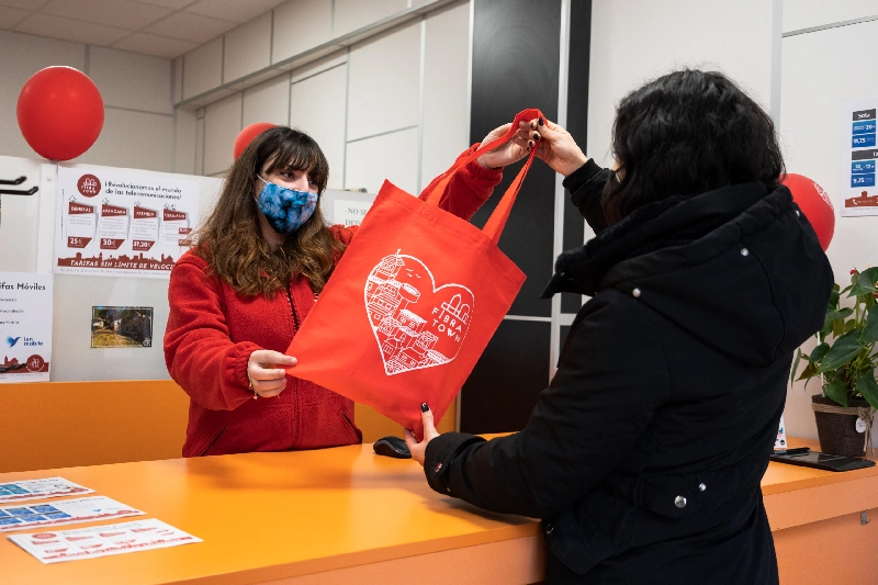 Clienta recibiendo la bolsa de la compra Fibratown en el recibidor de la tienda de Casas-Ibáñez