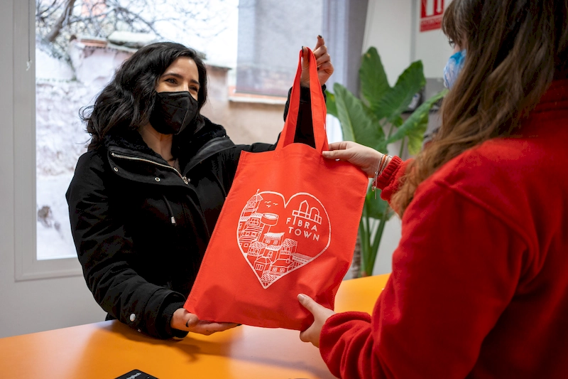 Fotografía de una dependienta dando a una clienta la bolsa de la compra Fibratown