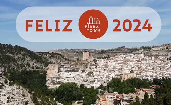 Imagen Fibratown Portada post - Feliz 2024 en la que se aprecia una panoramica de Alcala del jucar Junto a un rotulo que pones Feliz 2024 Junto al logotipo de Fibratown