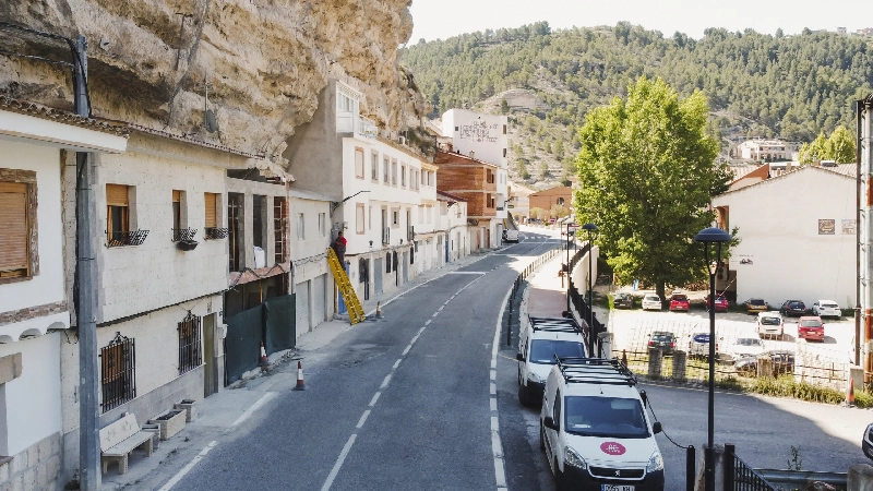 Imagen de los técnicos de Fibratown subidos en una escalera desplegando la fibra óptica en las calle s del pueblo de Alcalá del Júcar