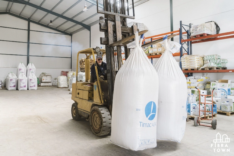 Fotografía de una carretilla cargando sacos con material ecológico