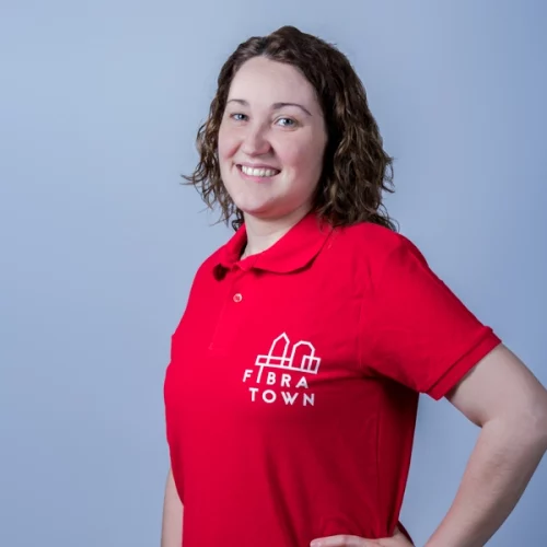 Retrato de estudio de Arantxa, administrativa de Fibratown. Ella porta el polo de rojo de la empresa con el logo de Fibratown estampado en la parte izquierda