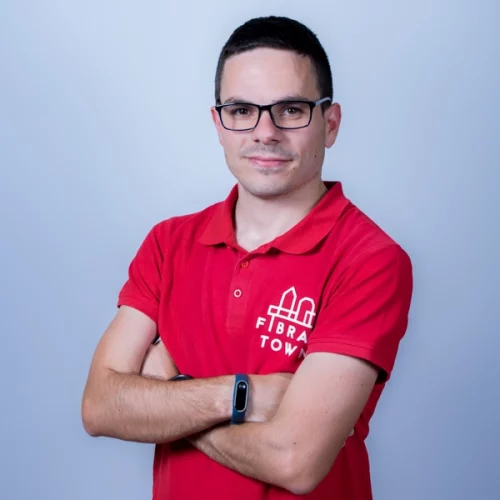 Retrato de estudio de Carlos, técnico de sistemas de Fibratown. Ella porta el polo de rojo de la empresa con el logo de Fibratown estampado en la parte izquierda