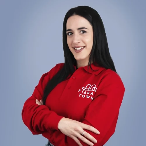 Retrato de estudio de Laura, administrativa de Fibratown. Ella porta el polo de rojo de la empresa con el logo de Fibratown estampado en la parte izquierda